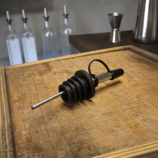 Close-up of olive oil flowing from an Aquiferra pourer attached to the bottle.